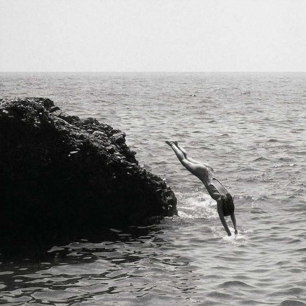 girl diving into sea from rock